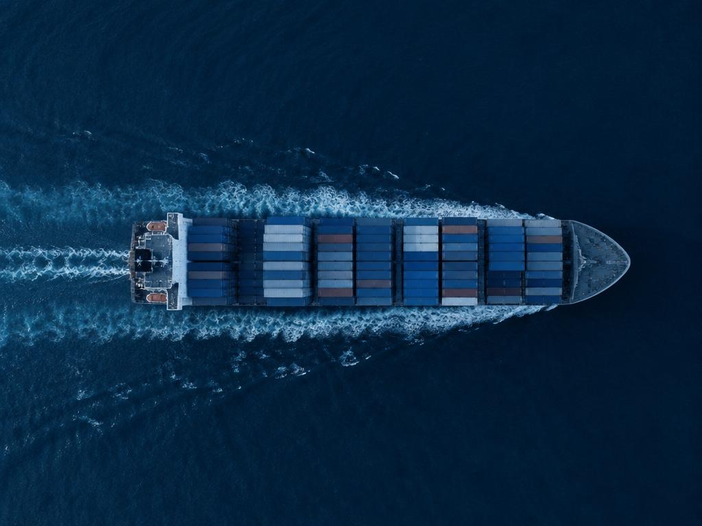 Aerial view of a loaded container ship sailing across open sea